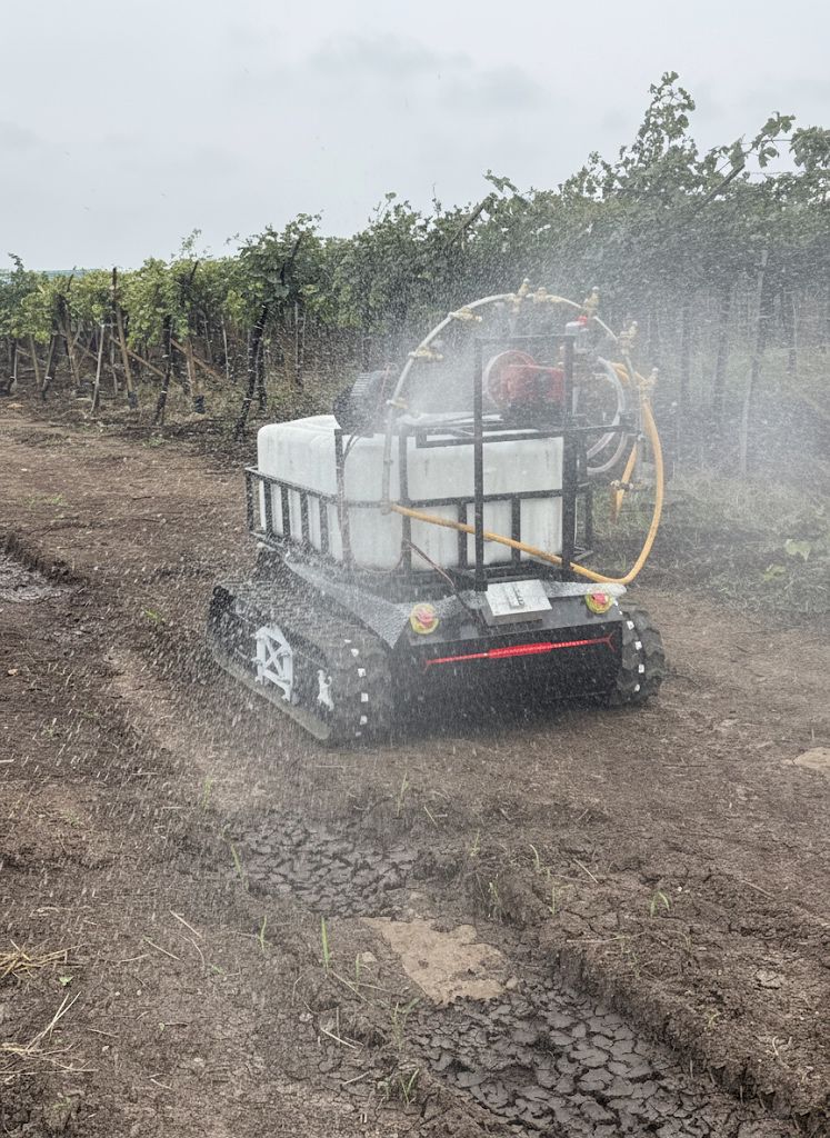 ASSIST tracked vehicle performing live spraying in a vineyard